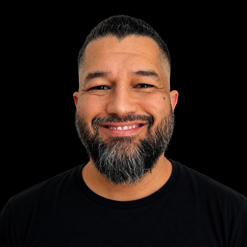 Junior Gaino — retrato editorial close-up sorrindo, fundo preto